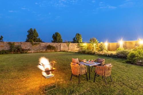 a backyard with a table and chairs and a fire place at ELIVAAS 2 BHK Pet Friendly Villa with Pvt Pool - Heaven in Hill in Udaipur