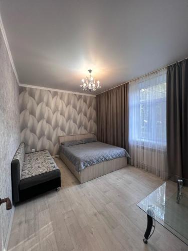 1 dormitorio con cama, sofá y mesa en На Майлина en Turksib