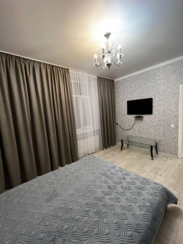 1 dormitorio con 1 cama y TV de pantalla plana en На Майлина en Turksib
