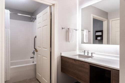 y baño con lavabo, espejo y bañera. en Staybridge Suites Akron-Stow-Cuyahoga Falls, an IHG Hotel, en Stow