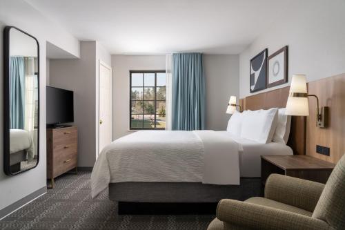 Habitación de hotel con cama y silla en Staybridge Suites Akron-Stow-Cuyahoga Falls, an IHG Hotel, en Stow