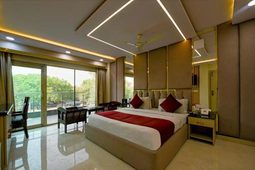 a bedroom with a large bed and a desk with a desk at Staybook South Delhi in New Delhi