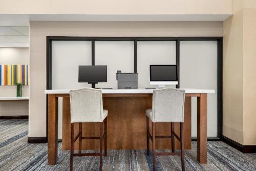 a conference room with two chairs and a desk with two monitors at Holiday Inn Express & Suites Mobile West I-10 by IHG in Tillmans Corner