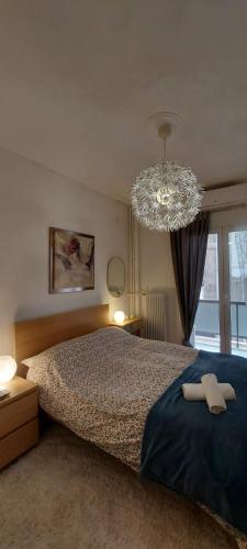 um quarto com uma cama grande e um lustre em Flat in King's George B' Street em Piraeus