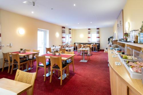 un restaurante con mesas y sillas y una cafetería en Hotel An der Eiche, en Kulmbach