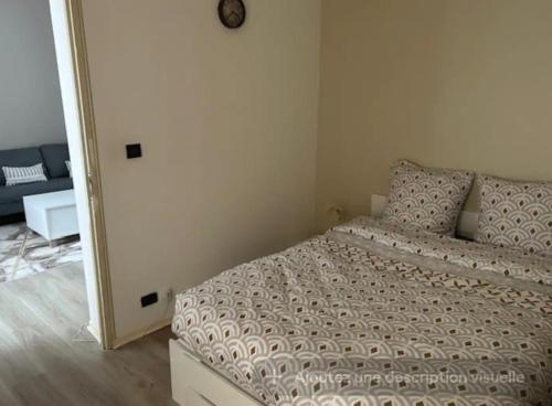 ein Schlafzimmer mit einem Bett und einer Uhr an der Wand in der Unterkunft Appartement type F2 in Soissons