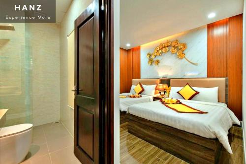 a bedroom with two beds and a bathroom at HANZ Gia Hoang Hotel in Da Lat