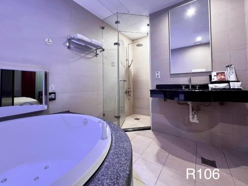 uma casa de banho branca com uma banheira e um lavatório em Catwalk Motel -Tainan em Tainan