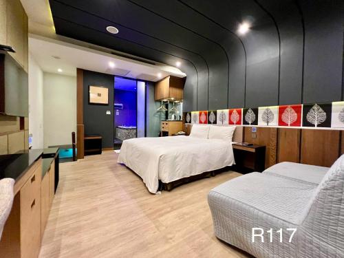 een hotelkamer met 2 bedden en een bank bij Catwalk Motel -Tainan in Tainan