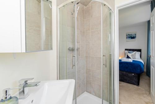 y baño con ducha y lavamanos. en Relaxing 4 Bedroom Retreat For Long Stays Fawley, en Totton