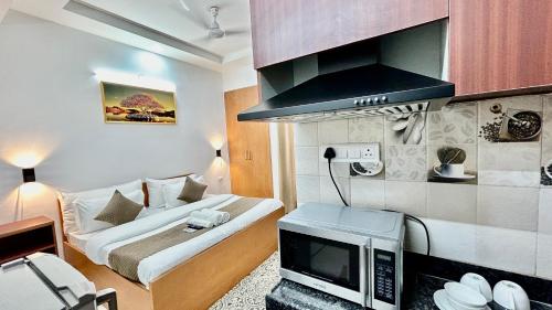 uma pequena sala de estar com um sofá e uma televisão em Aura Luxury Studio Near Golf Course Road, Sector 57, Gurgaon em Gurgaon