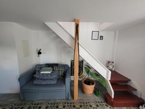 a living room with a blue couch and stairs at Get-your-flat - Wohnen im Eulenturm tiny owl-house - naturnah & einzigartig - 60 m2 - Haustier auf Anfrage OG1 in Hagen