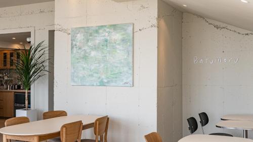 a table and chairs in a restaurant with a map on the wall at Jimi Stay in Jeju