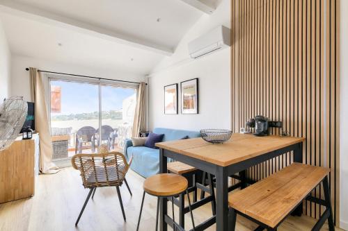 un salon avec une table et des chaises en bois dans l'établissement Domaine de la Gaillarde - maeva Home - Appartement chaleureux avec balcon 3 pièces 4 personnes - Prestige - super Home MAE-9791, à Roquebrune-sur Argens