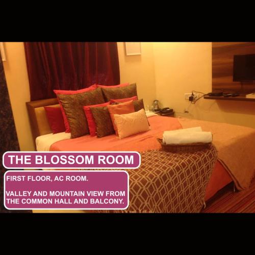 a bedroom with a bed with orange sheets and pillows at Strawberry County in Panchgani