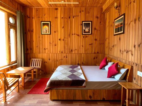 a bedroom with a bed in a wooden wall at Apple Blush Retreat - Tirthan Valley in Gushaini