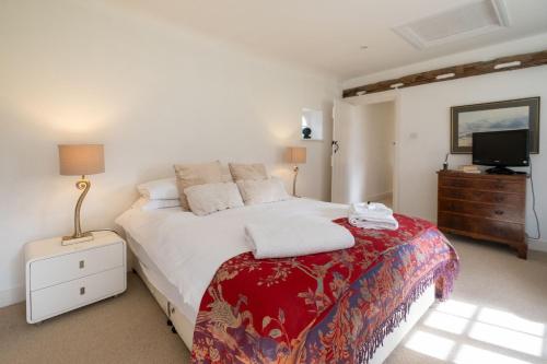 a bedroom with a large bed and a tv at Spilfeathers Cottage in Freyerning