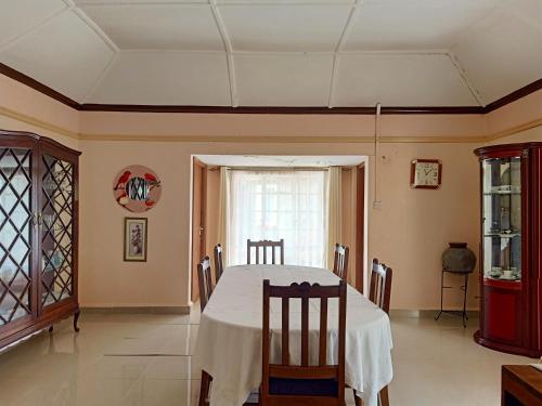 uma sala de jantar com mesa e cadeiras em NICK'S AND ESSY'S PLACE em Juja