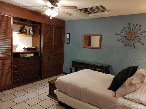a bedroom with a bed and a couch in a room at Aparta-Hotel CASA REAL Apartamentos in Chapala