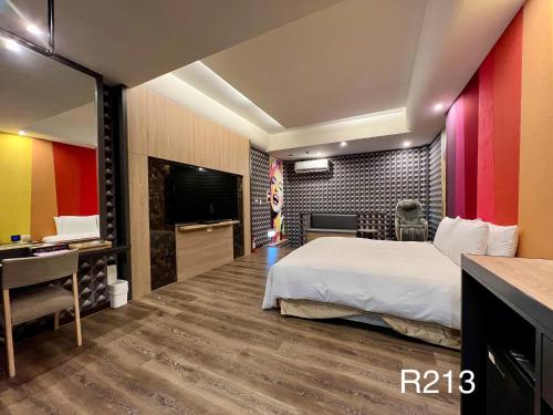 a hotel room with a bed and a television at Cigar Motel in Tainan