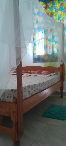 1 dormitorio con 1 cama con dosel en Saloome Accommodation Mikindani, en Mombasa