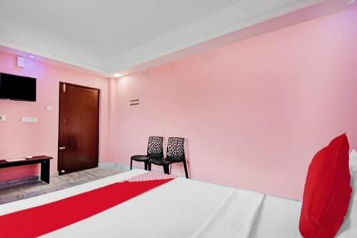 una camera con un letto e due sedie e una scrivania di Hotel Rose a kolkata