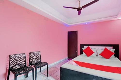 una camera rosa con un letto e due sedie di Hotel Rose a kolkata