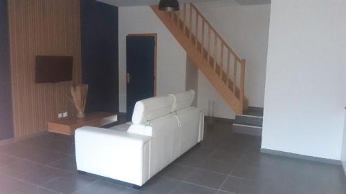 a living room with a white couch and stairs at Gite 4 personnes Proche d'Arras in Warlus