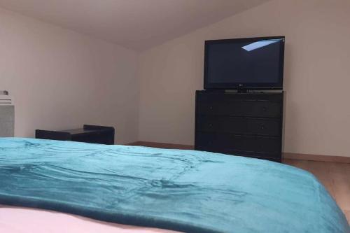 une chambre avec un lit et une télévision sur une commode dans l'établissement Gite 4 personnes Proche d'Arras, à Warlus