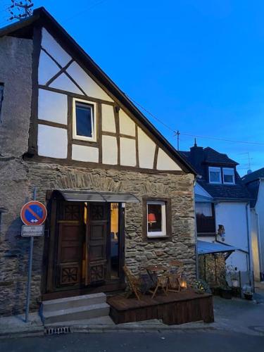 a stone building with a door and a window at Ferienhaus Cottage in Alf an der Mosel in Alf