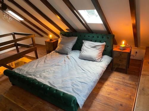 a bed with a green headboard in a room at Ferienhaus Cottage in Alf an der Mosel in Alf