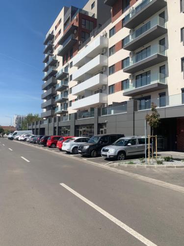 um parque de estacionamento com carros estacionados em frente a um edifício em Premium Residence ApartHotel em Oradea