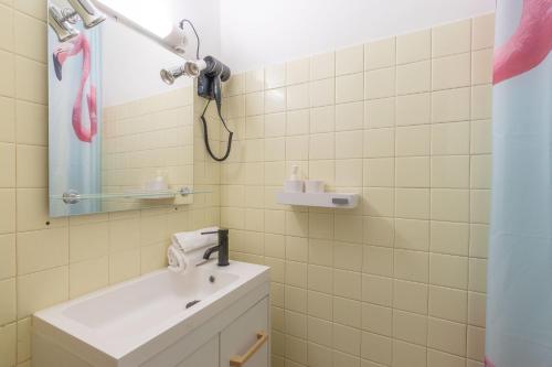 une salle de bain avec un lavabo et un miroir dans l'établissement Cabana & Miami 70's - Proche Parking et Épicerie, à Mâcon