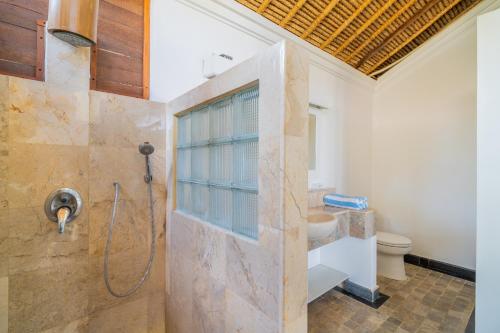 a bathroom with a shower and a toilet at Scuba Seraya Resort in Tulamben