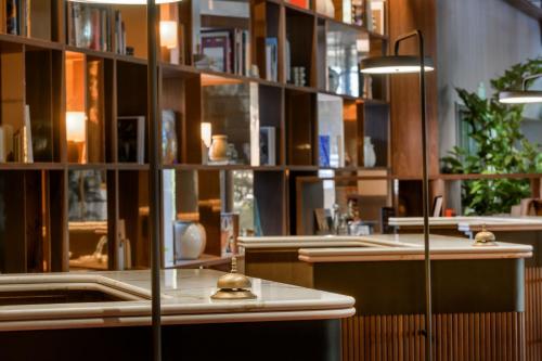 a library with bookshelves and a table in a room at AC Hotel Cuzco by Marriott in Madrid