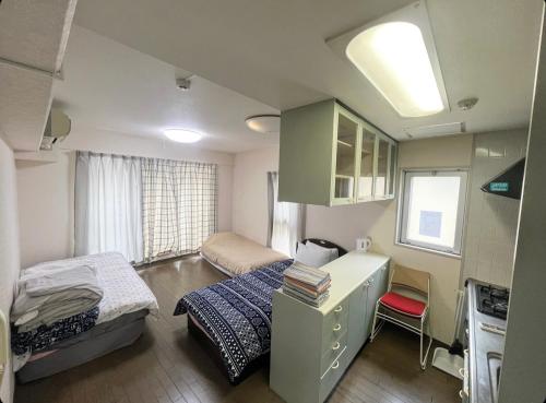 een kleine kamer met 2 bedden en een bureau bij MATUBARA HOUSE in Tokyo