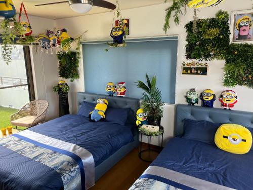 een slaapkamer met 2 bedden en gevulde minions bij Yokkaichi City Guest House in Yokkaichi