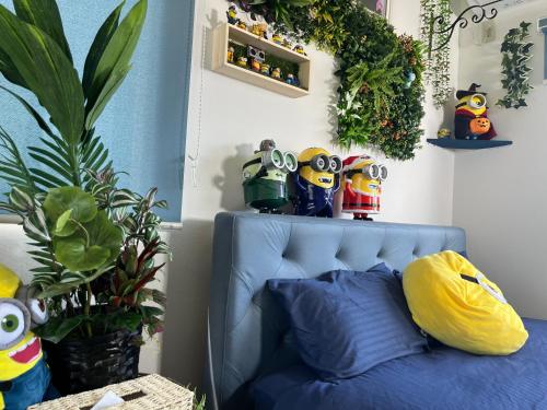 四日市市にあるYokkaichi City Guest Houseの壁に植物が植わる客室の青いベッド1台