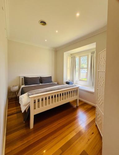 a bedroom with a large bed and a window at Lovely Home in Melbourne