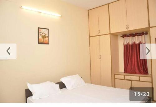 um quarto com 2 camas e uma cortina vermelha em Shree Eco Stay em Chennai