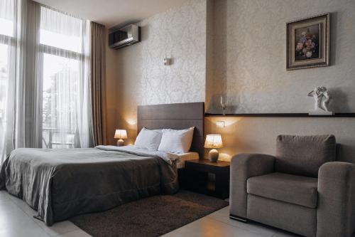 a hotel room with a bed and a chair at Monte Carlo in Batumi