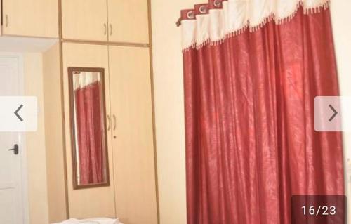 um quarto com uma cortina vermelha e um espelho em Shree Eco Stay em Chennai