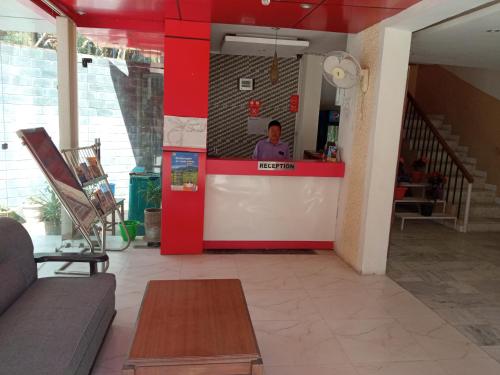 Un hombre de pie en el mostrador de un restaurante. en vella marina group of hotel Ravine, en Dharamshala