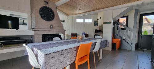 une salle à manger avec une table, des chaises et une horloge dans l'établissement Aux Passagers de la Baie, au Crotoy