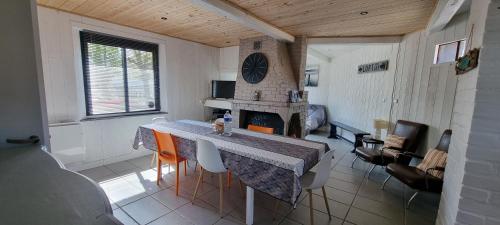 uma sala de jantar com uma mesa e uma lareira em Aux Passagers de la Baie em Le Crotoy