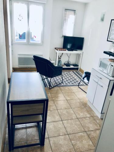 une cuisine avec une table et des chaises dans une pièce dans l'établissement Le Bohème Charmant appartement meublé avec parking, à Amélie-les-Bains-Palalda