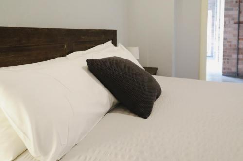 a black pillow sitting on top of a white bed at Royal Hotel Capertee in Capertee