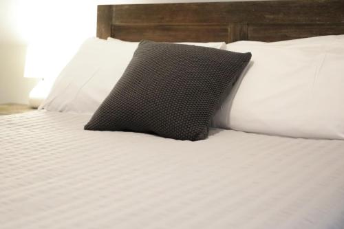 a black pillow sitting on a bed with white pillows at Royal Hotel Capertee in Capertee