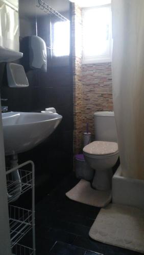 a bathroom with a sink and a toilet at The Best in Perissa