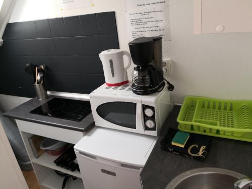 un comptoir de cuisine avec un four micro-ondes. dans l'établissement Idéalement situé - jardin agréable - studio E, à Berck-sur-Mer